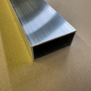May include: A silver aluminum rectangular tube with a brushed finish.
