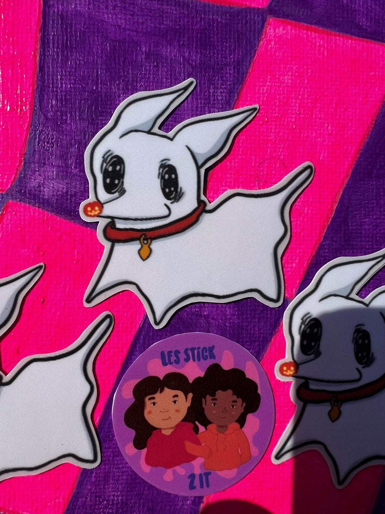 May include: Three stickers on a purple and pink background. Two stickers are white cartoon ghost dogs with black eyes and a red collar. The third sticker is a purple circle with two cartoon people with brown hair and brown skin. The text "LES STICK" and "2IT" are on the sticker.