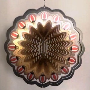 May include: A decorative metal wind spinner with a layered design featuring red and white hot air balloons. The spinner has a black metal frame and is designed to rotate in the wind.