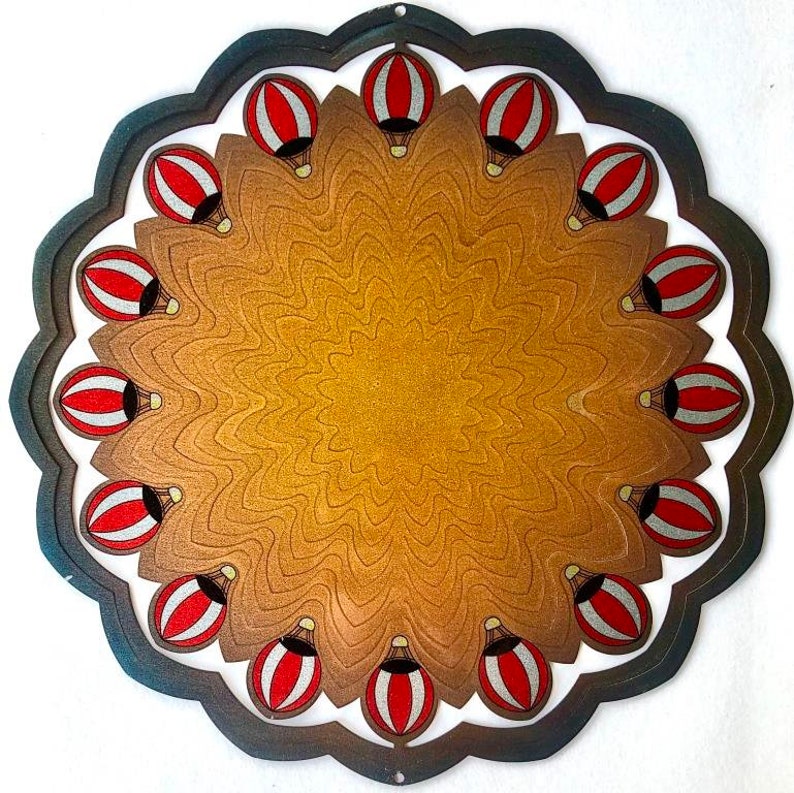 May include: A metal wind chime with a circular design featuring a brown background and red and white hot air balloons. The balloons are arranged in a circular pattern around the center of the chime.