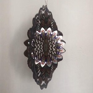 May include: A multi-layered metal wind spinner with a diamond shape. The spinner features a colorful, intricate design with shades of brown, white, blue, red, and gold.