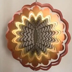 May include: A multi-layered, circular wind spinner with a swirling pattern. The spinner is made of metal and has a copper, gold, and brown color scheme.