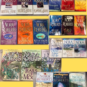 May include: A collection of Nora Roberts novels, featuring various titles with colorful covers. The books are arranged in rows, showcasing a variety of cover designs and titles, including "Hidden Star" and "Dance of the Gods."