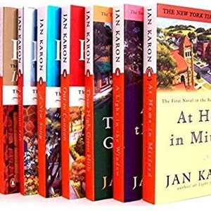 May include: A collection of 12 paperback books by Jan Karon, featuring the title "At Home in Mitford" and the text "The First Novel in the Beloved Mitford Series". The books are arranged vertically, with the spines facing the viewer. The books are all different colors, including red, blue, green, and purple.