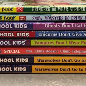 May include: A stack of ten children's books with colorful covers featuring the title "The Bailey School Kids". The books have different titles, including "Reindeer Do Wear Striped Underwear", "Snow Monsters Do Drink Hot Chocolate", "Ghosts Don't Eat Potato Chips", "Unicorns Don't Give Sleigh Rides", "Vampires Don't Wear Polka Dots", "Mrs. Claus Doesn't Climb Telephone Poles", "Werewolves Don't Go to Summer Camp", and "Werewolves Don't Go to Summer Camp".