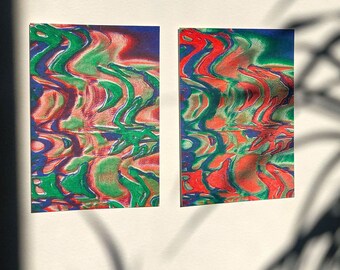 Pode incluir: Duas impressões de arte abstrata com um padrão psicodélico em espiral em tons de vermelho, verde e azul. As impressões são emolduradas e penduradas em uma parede branca.
