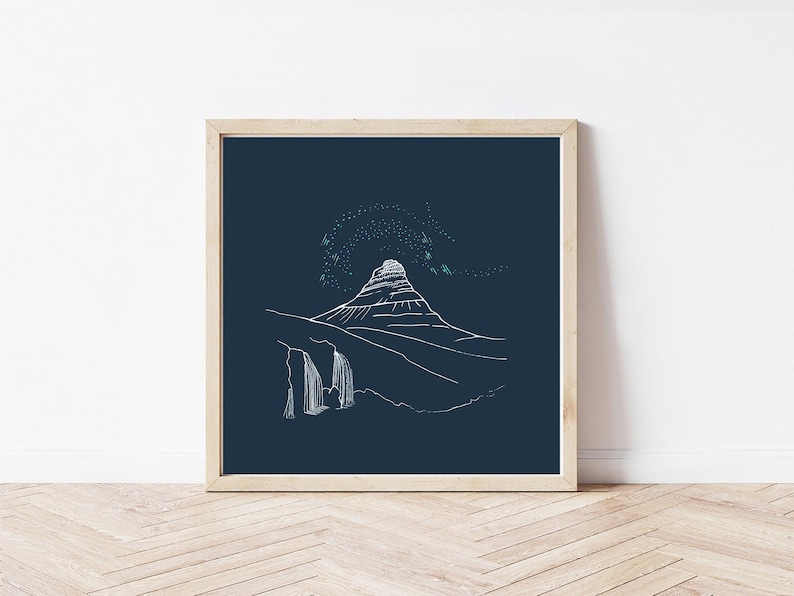 May include: A framed art print featuring a minimalist line drawing of a mountain landscape with a waterfall. The artwork is rendered in white against a dark blue background, with a light wooden frame.