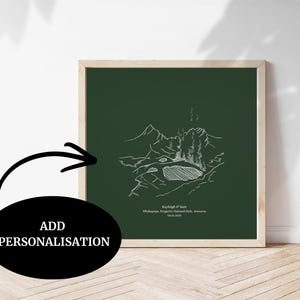 May include: A framed print with a white line drawing of a mountain scene on a dark green background. The print has text at the bottom and is in a light wood frame. The words "ADD PERSONALISATION" are in a black oval.