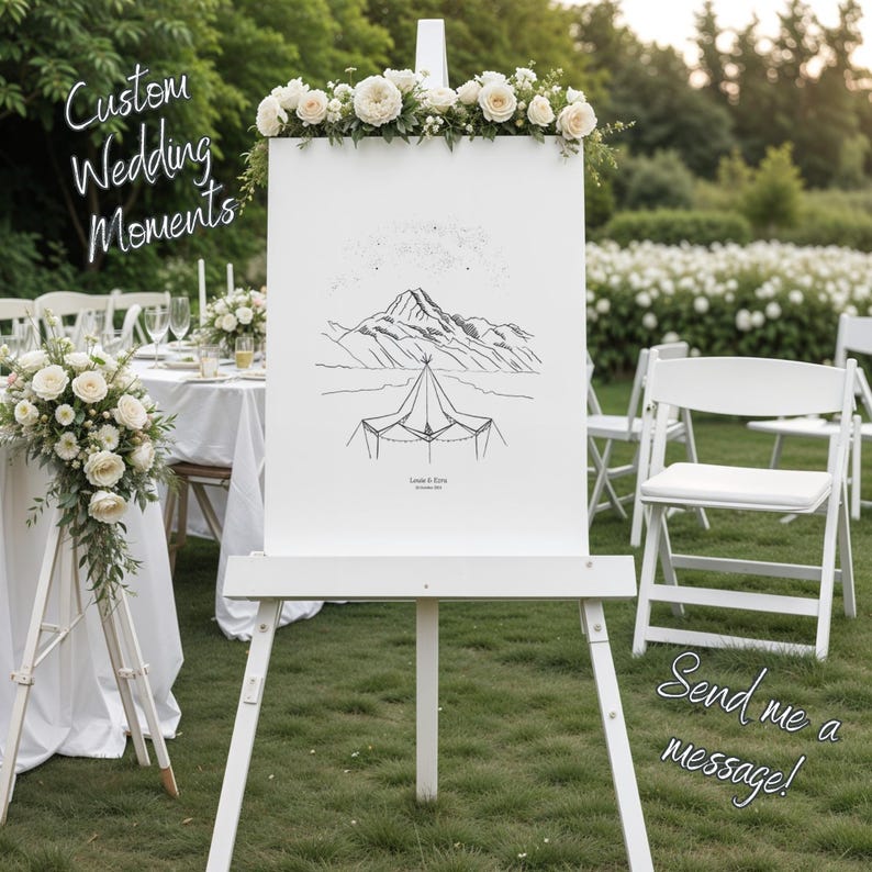 May include: A white wedding sign on an easel, decorated with flowers. The sign displays a mountain and tent illustration, with the text "Custom Wedding Moments" and "Send me a message!". The setting is outdoors, with white chairs and a table visible.