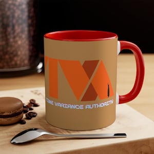 May include: A brown ceramic coffee mug with a red rim and handle. The mug features a stylized orange and brown logo that reads "Time Variance Authority".