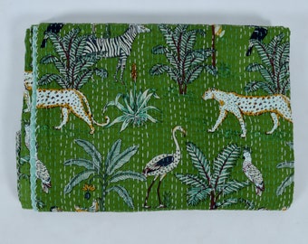 Puede incluir: Una colcha kantha verde con un borde blanco. La colcha presenta un patrón repetido de cebras, leopardos, flamencos y palmeras.