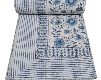 May include: A white cotton quilt with a blue floral pattern. The quilt has a border of blue stripes and a floral design.