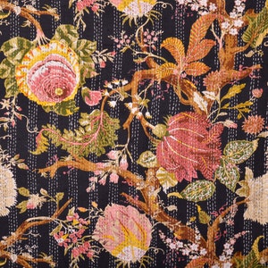 May include: Black fabric with a repeating pattern of pink, yellow, and green flowers and leaves. The fabric has a quilted texture.