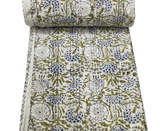 May include: A white cotton quilt with a green and blue floral pattern. The quilt is rolled up and has a white border.