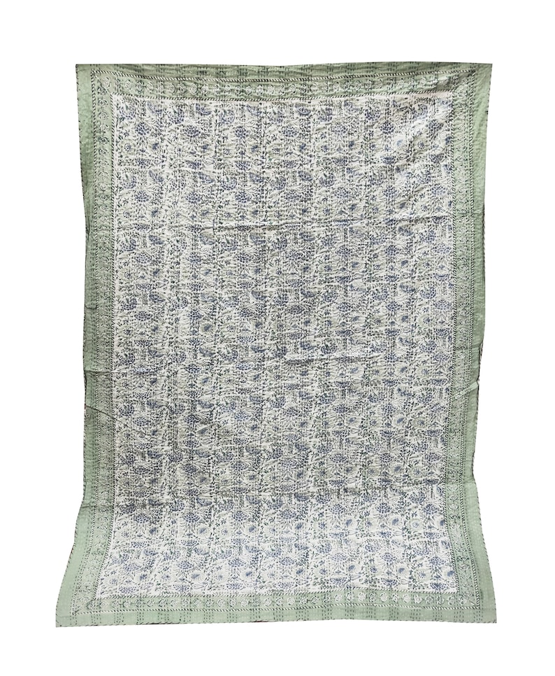 May include: A green and white kantha quilt with a floral pattern. The quilt has a border of green fabric with a white pattern.