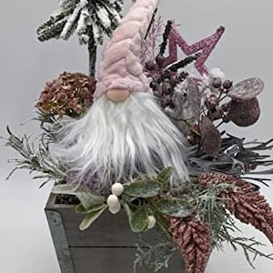 Arreglo de mesa de invierno con gnomo, estrella, abeto, brezo, hierbas, rosa y gris.