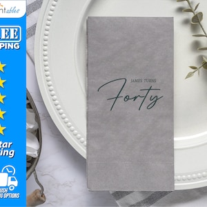 May include: Gray paper napkin with the text "JAMES TURNS Forty" in a handwritten style.