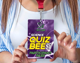 May include: A rectangular identification badge hanging from a dark red lanyard. The badge features a purple background with white atomic graphics and the text SCI-LAB, SCIENCE QUIZ BEE 2028, and PARTICIPANT PASS in bold yellow and green lettering.