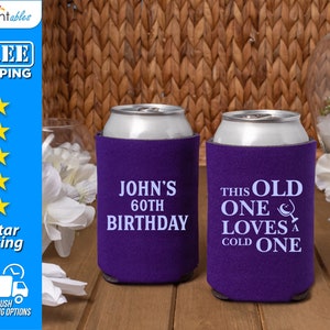 May include: Two purple can coolers with white text. One cooler says "John's 60th Birthday" and the other says "This Old One Loves a Cold One".