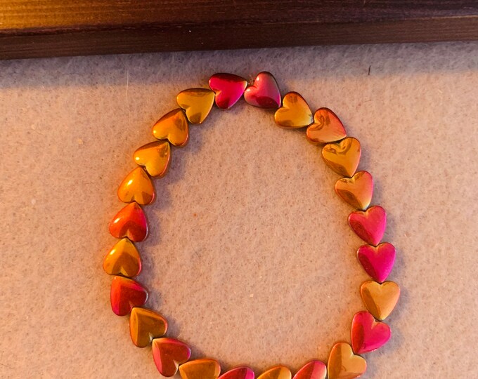 Heart beaded stretch bracelet- plated hematite stones with pink and orange hues