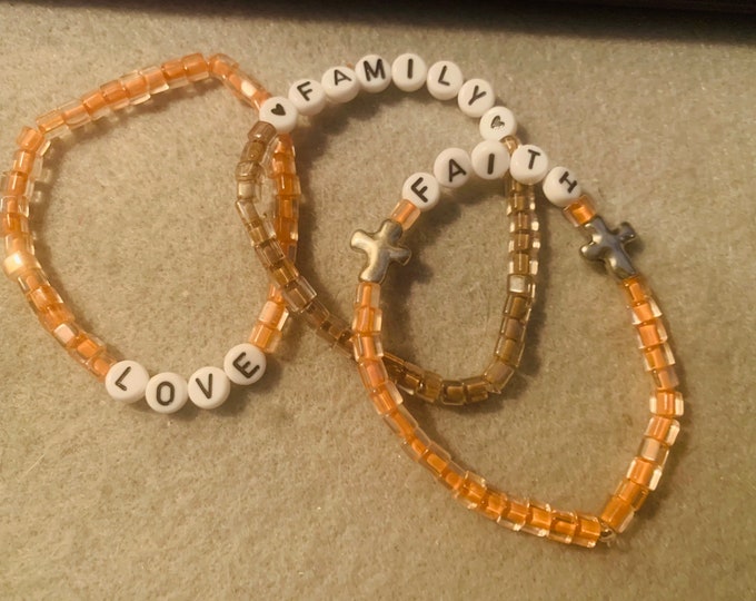 Sparkly peach and brown colored personalized beaded stretch bracelet set of 3 with “faith, love, family”. Can be personalized.