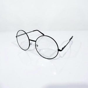 May include: A pair of round eyeglasses featuring thin black metal frames and clear lenses. The glasses have a simple bridge, adjustable nose pads, and slender temples that extend from the outer edges of the circular rims to rest behind ears.