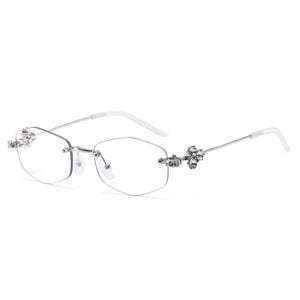 May include: Rimless eyeglasses with a silver frame and clear lenses. The temples are white, and the hinges are adorned with clusters of sparkling rhinestones. The glasses have a modern, elegant design.