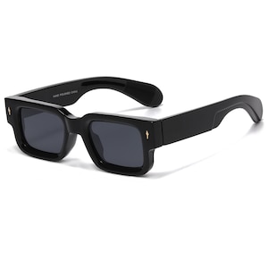 May include: Black sunglasses with a square frame and dark lenses. The sunglasses have a thick, bold frame with a small gold accent on each side. The text "HAND POLISHED CHINA" is printed on the arm.