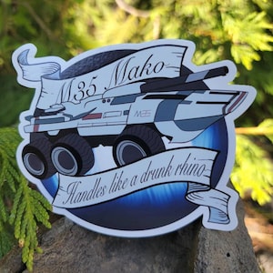 May include: A white and gray M35 Mako vehicle with a blue and white background. The vehicle has six wheels and a banner that reads "Handles like a drunk rhino".