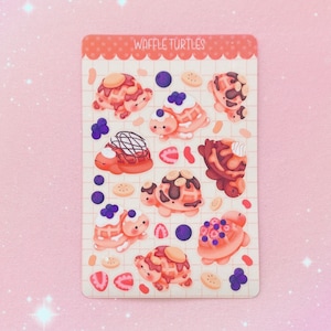 May include: A sheet of stickers featuring waffle turtles with various toppings, including chocolate, whipped cream, and fruit. The stickers are on a pink and white background with the text "Waffle Turtles" at the top.