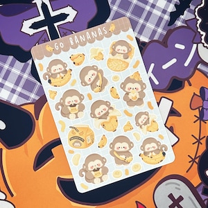 May include: A sheet of stickers featuring cartoon monkeys eating bananas. The stickers are on a white background with a blue grid pattern. The text "Go Bananas" is at the top of the sheet.