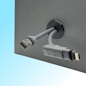 Op de afbeelding: Een close-up van een grijs computerpaneel met twee grijze kabels die uit een zwarte grommet komen. Eén kabel heeft een RJ45-connector en de andere een USB-C-connector.