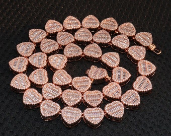 May include: A rose gold heart-shaped chain necklace with clear cubic zirconia stones. The necklace is made of metal and has a polished finish.