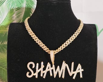 May include: Gold chain necklace with a pendant that says "SHAWNA" in sparkly, script lettering.