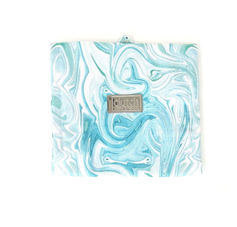 May include: A blue and white marbled fabric clutch bag with a silver metal tag that reads "clutch" and "SAPA GORMAIL".