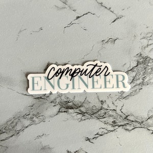 Op de afbeelding: Witte sticker met blauwe tekst die "computer ENGINEER" luidt op een grijze marmeren achtergrond.