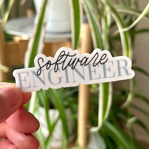 May include: A white sticker with blue text that reads "Software Engineer" in a cursive font.