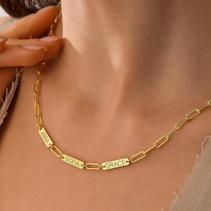 May include: Gold chain necklace with three rectangular name tags that read "Anna", "Sofia", and "Grace".