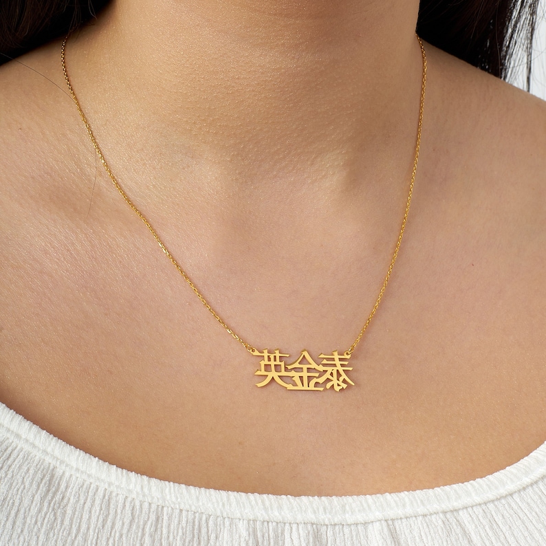 Peut inclure: Un collier en cha&icirc;ne dor&eacute;e avec un pendentif repr&eacute;sentant les caract&egrave;res chinois pour "chanceux" en or.