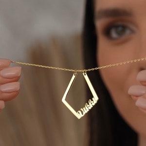 May include: A gold necklace with a diamond-shaped pendant featuring the name "Vikki" in cursive script.