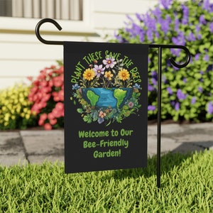 May include: A black garden flag with a colorful illustration of a globe surrounded by flowers and bees. The text on the flag reads "Plant These Save The Bees" and "Welcome to Our Bee-Friendly Garden!"