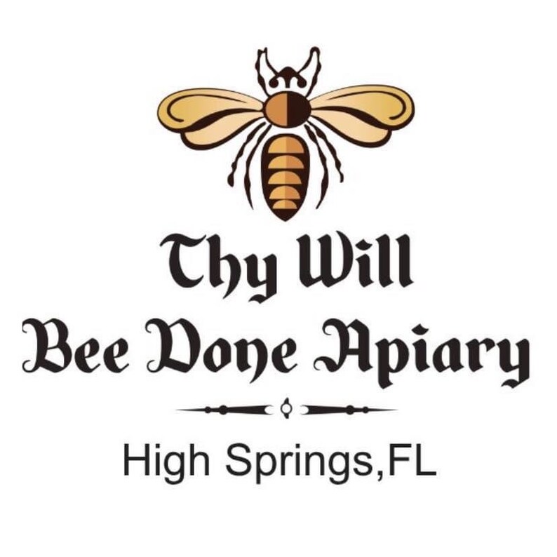 May include: A logo featuring a stylized brown and tan bee icon centered above the black text Thy Will Bee Done Apiary, with a decorative horizontal line separator and the location text High Springs, FL, all set against a plain white background.