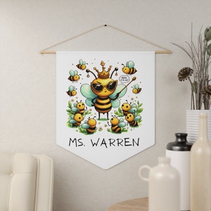 May include: A white banner with a cartoon bee wearing sunglasses and a crown. The bee is holding a pointer and says "Order in the hive!" There are other bees around the main bee. The banner says "Ms. Warren" at the bottom.