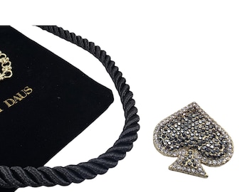 Conjunto de broche de cristal con forma de pala y collar con cordón negro "Dealers Choice Spade" de Heidi Daus.