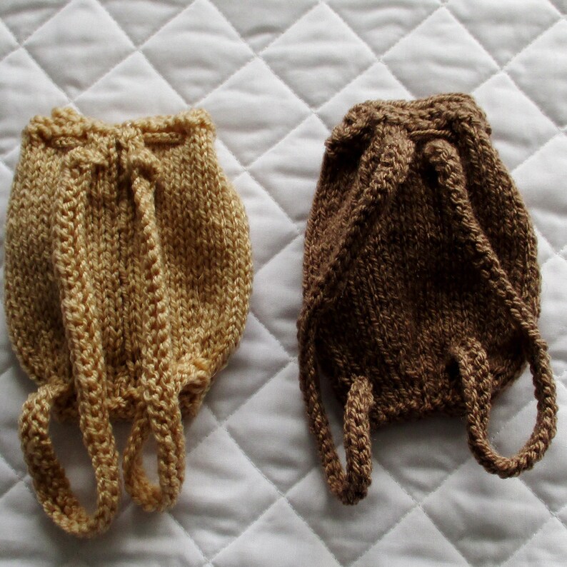 May include: Two knitted bags with straps. One bag is tan and the other is brown.