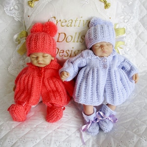 Pode incluir: Dois conjuntos de boneca de bebê de malha, um em rosa e outro em lavanda. Ambos os conjuntos incluem um chapéu, um casaco e botinhas. As bonecas estão deitadas em um fundo branco com um travesseiro que diz "Creative Dolls Design".