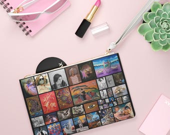 May include: A black clutch with a gold zipper and a wrist strap, featuring a collage of colorful artwork. The image also shows a pair of white sunglasses, a pink lipstick, a succulent plant, and a pink notepad.