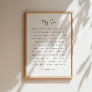 May include: A rectangular wall art print in a light wood frame featuring the text My Son, followed by the biblical passage Proverbs 6:20-23 in black serif font on a white background. The text provides guidance and instruction for life.