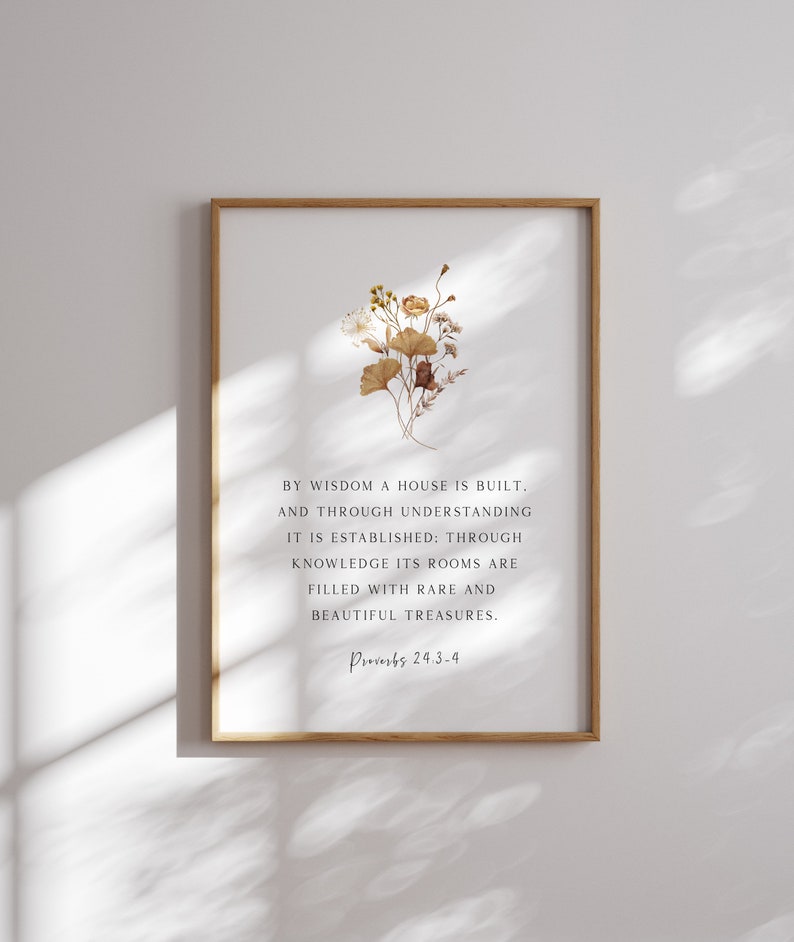 K&ouml;nnte beinhalten: Ein gerahmter Wandkunstdruck mit einem kleinen Strau&szlig; getrockneter brauner und gelber Blumen &uuml;ber dem Text: BY WISDOM A HOUSE IS BUILT, AND THROUGH UNDERSTANDING IT IS ESTABLISHED: THROUGH KNOWLEDGE ITS ROOMS ARE FILLED WITH RARE AND BEAUTIFUL TREASURES. Proverbs 24:3-4.