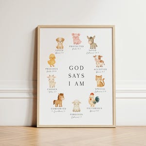 May include: A framed wall art print featuring watercolor illustrations of ten farm animals arranged in a circle around the text GOD SAYS I AM. Each animal is paired with a descriptive word and a Bible verse reference in black serif font.
